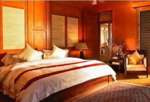 een slaapkamer met een groot bed en een stoel bij Duyong Marina & Resort in Kuala Terengganu