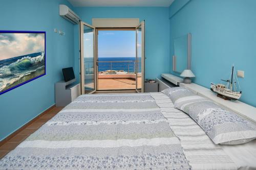 a bedroom with a large bed with a view of the ocean at Villa Blue Dream in Koutsounari