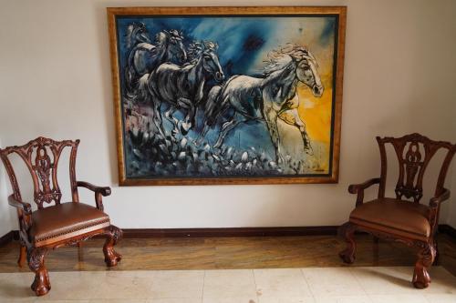 a painting of a group of horses on a wall at Hotel Boutique Villa Casuarinas in Cali