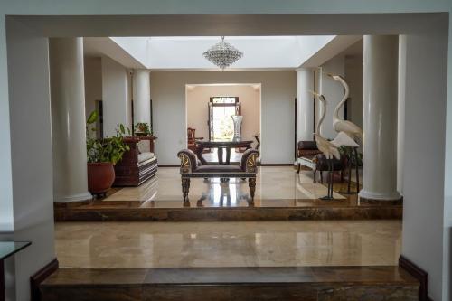 a lobby with a bench in the middle of a room at Hotel Boutique Villa Casuarinas in Cali