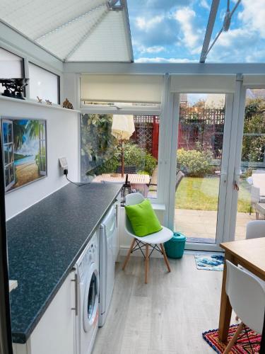 a kitchen with a washer and dryer with a green at Stunning Seafront House with garden and private parking in Eastbourne