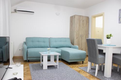 - un salon avec un canapé bleu et une table dans l'établissement Sweet Home Vrnjačka Banja, à Vrnjačka Banja