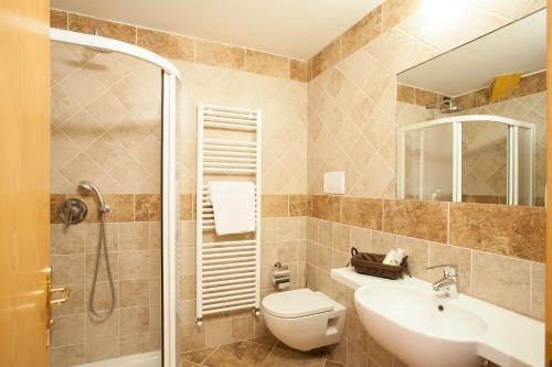 a bathroom with a toilet and a sink and a shower at Hotel Vittoria in Folgaria