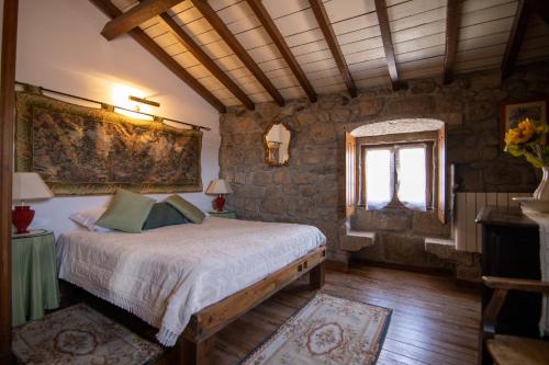 a bedroom with a bed in a room with a window at Casa da Vila in Sortelha