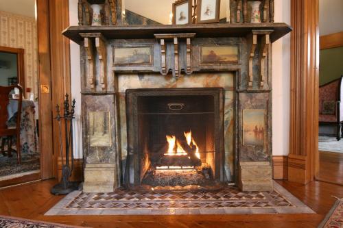 a fireplace in a living room with a fire in it at The Governor's Inn in Ludlow