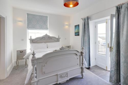 a bedroom with a white bed and a window at Master accommodation suite 2 sea view with balcony in Hastings