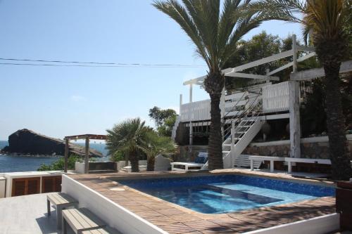a swimming pool with palm trees and a staircase at The One-SweethomeRooms Cabo de Palos in Cabo de Palos