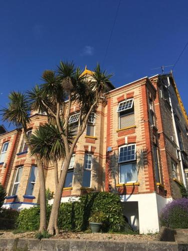 a building with palm trees in front of it at The Attic Apartment at Number 54 in Ilfracombe