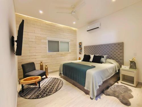a bedroom with a large bed and a chair at 1st Luxury Warehouse in Cancún