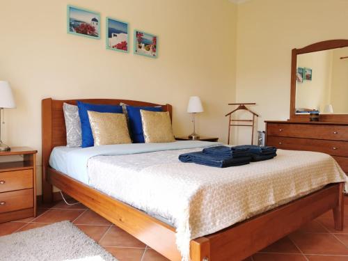アルマカオ・デ・ペラにあるCharming Beach Apartmentのベッドルーム(青い枕と鏡付きのベッド1台付)