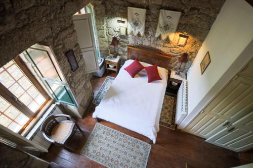 einen Blick über ein Schlafzimmer mit einem Bett und einem Fenster in der Unterkunft Casa do Campanário in Sortelha