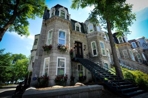 a large stone building with stairs in front of it at Le 555 Hébergements touristiques in Quebec City