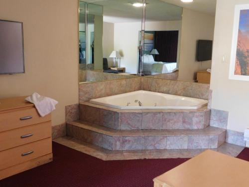 a large bathroom with a tub and a bedroom at Days Inn by Wyndham Novato/San Francisco in Novato