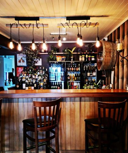 a bar with two chairs and a counter with alcohol at Parklands Motorlodge & Holiday Park in Turangi