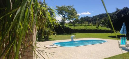 ein kleiner Pool mit einem Wasserhahn im Hof in der Unterkunft Sítio entre Santo Antonio Pinhal e Campos do Jordão in Santo Antônio do Pinhal