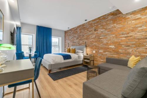 a bedroom with a bed and a brick wall at INITIAL - SUITE LEMIEUX - PARKING - Centre-Ville de Québec in Quebec City