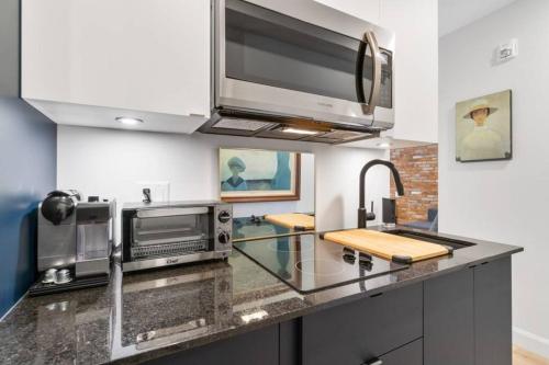 ケベック・シティーにあるINITIAL - SUITE LEMIEUX - PARKING - Centre-Ville de Québecのキッチン(電子レンジ、シンク付)