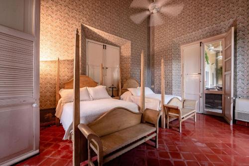 a bedroom with two beds and a ceiling fan at Hacienda San Antonio Millet in Tixkokob