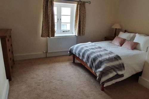 A bed or beds in a room at Renovated cosy cottage within Cranborne Chase