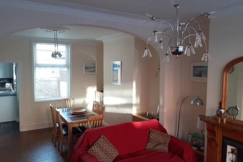 a living room with a red couch and a table at Seaside Home from Home 4bedroom sleeps 8 in Bridlington