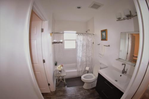 Baño blanco con aseo y lavamanos en Upper East Side Oasis, en Miami