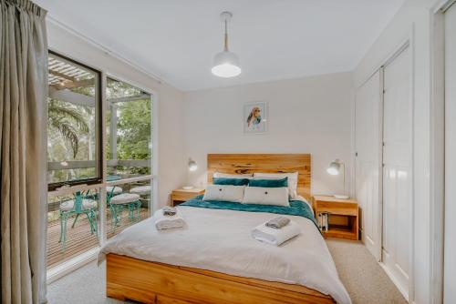 a bedroom with a large bed and a window at Steep Creek Retreat in Belgrave