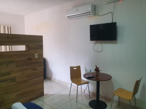 Una habitación con una mesa y sillas y un televisor. en Las Salinas Hostal, en Luque