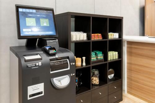a cash register with a computer in a room at Chisun Hotel Kamata in Tokyo