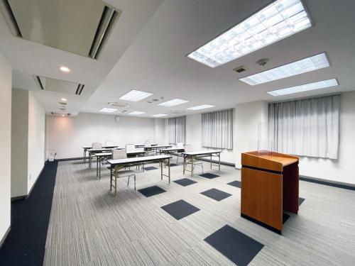 a large room with tables and chairs and windows at Chisun Hotel Kamata in Tokyo