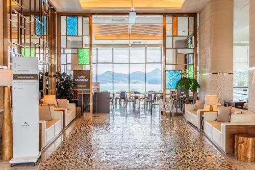 a lobby of a hotel with tables and chairs at Stanford Hotel&Resort Tongyeong in Tongyeong