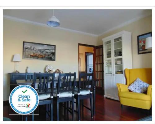 a dining room with a dining table and a yellow chair at Oporto East House in Porto