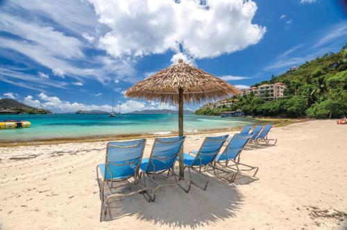 un gruppo di sedie sotto un ombrellone su una spiaggia di Margaritaville Vacation Club by Wyndham - St Thomas a Frydendal