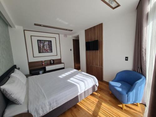 a bedroom with a bed and a blue chair at Ngan Hoa - Mille Fleurs 02 in Da Lat