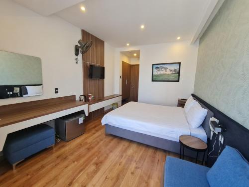 a hotel room with a bed and a flat screen tv at Ngan Hoa - Mille Fleurs 02 in Da Lat