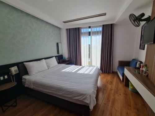 ein Hotelzimmer mit einem Bett und einem TV in der Unterkunft Ngan Hoa - Mille Fleurs 02 in Da Lat