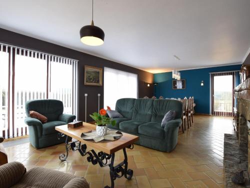 a living room with two couches and a table at Welcoming Holiday Home in Porcheresse with a large garden in Porcheresse