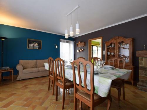 a dining room with a table and chairs and a couch at Welcoming Holiday Home in Porcheresse with a large garden in Porcheresse