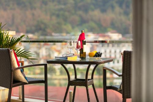 a table with wine glasses and a lamp on a balcony at Sapa Mountain Queen House in Sapa