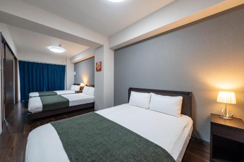 a hotel room with two beds and two lamps at Hotel Piacere NAMBA in Osaka