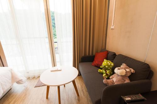 a living room with a couch with stuffed animals on it at Mu sun Villa 慕山休閒包棟民宿 宜蘭縣民宿2060號 in Dongshan