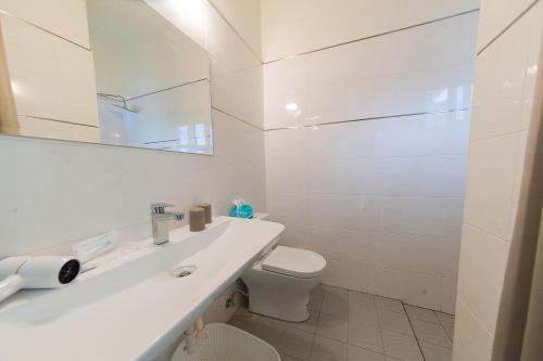a white bathroom with a toilet and a sink at Mu sun Villa 慕山休閒包棟民宿 宜蘭縣民宿2060號 in Dongshan