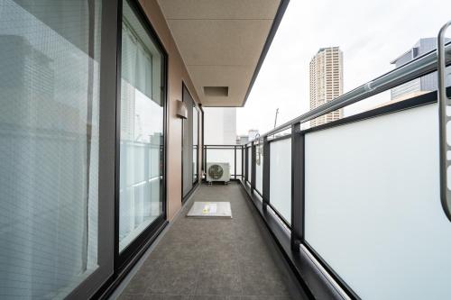 a hallway of an office building with glass windows at Hotel Piacere NAMBA in Osaka