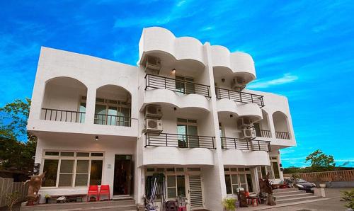 a white building with balconies on the side of it at Mu sun Villa 慕山休閒包棟民宿 宜蘭縣民宿2060號 in Dongshan