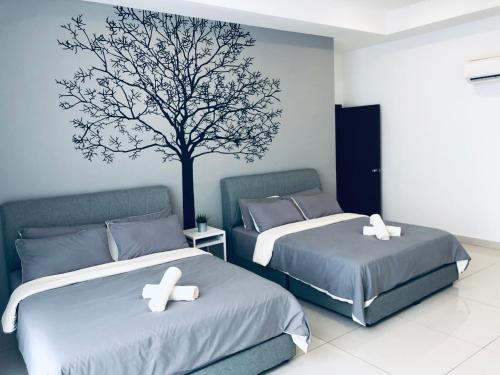 two beds in a room with a tree on the wall at KSL Desplanade By Antlerzone in Johor Bahru