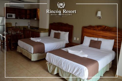 a hotel room with two beds and a kitchen at Rincon Resort in Los Ayala