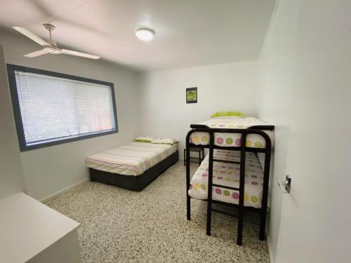 ein kleines Schlafzimmer mit 2 Betten und einem Fenster in der Unterkunft Koala Lodge Unit 3 in Iluka