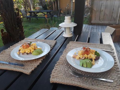 deux assiettes de nourriture sur une table en bois dans l'établissement Lady Bowen Bed & Breakfast, à Thames