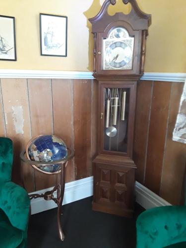 a grandfather clock and a table in a room at Lady Bowen Bed & Breakfast in Thames