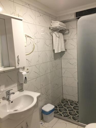 a white bathroom with a sink and a shower at karasu elmasotel in Sakarya