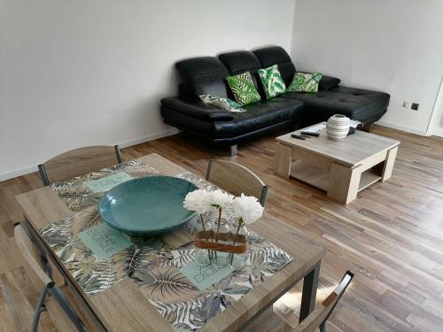 ein Wohnzimmer mit einem Tisch und einem Sofa in der Unterkunft T3 proche de la mer in Portel-des-Corbières